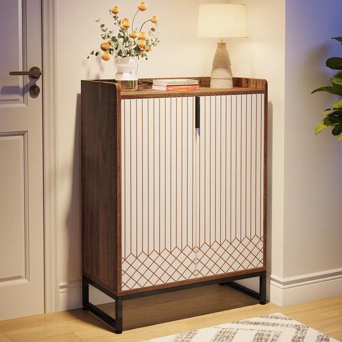 a white and brown cabinet next to a door with flowers on it in a living room