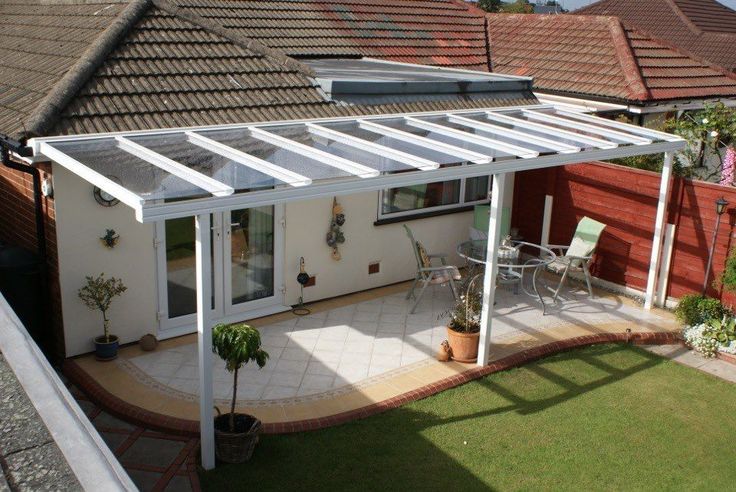 a white patio cover sitting on top of a lush green field