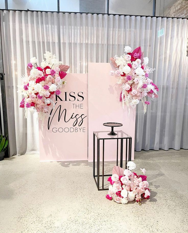 a table with flowers on it next to a sign that says kiss the miss goodbye