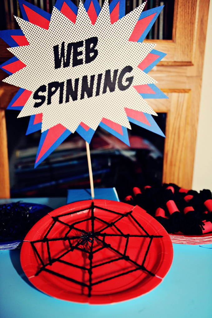 a spider web spinning sign on top of a table with desserts in front of it