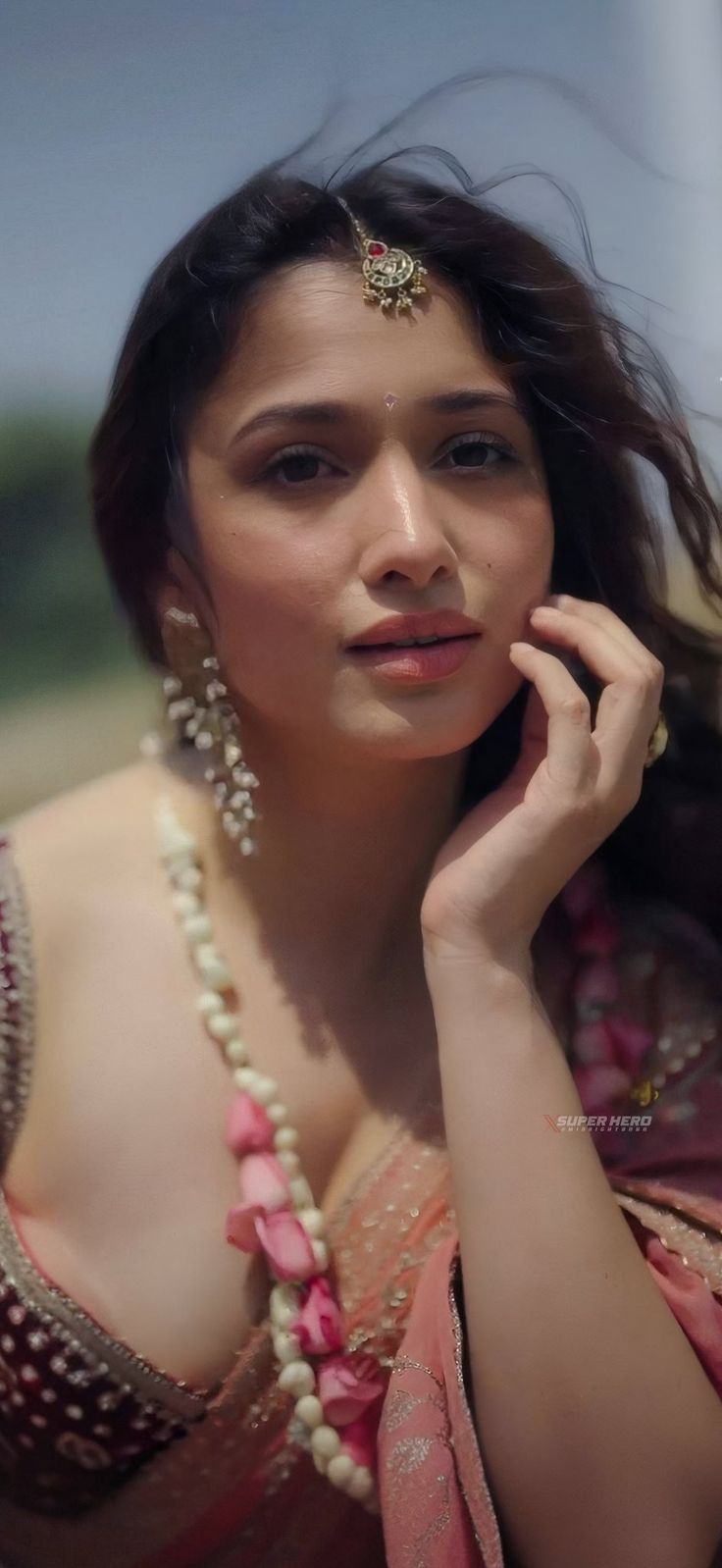 a woman in a pink sari with pearls on her head is posing for the camera