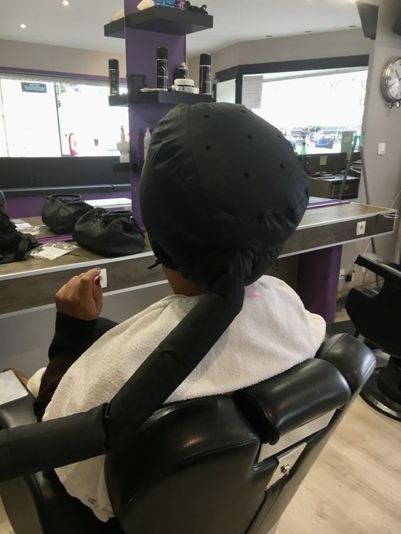 a person sitting in a chair with a hair dryer