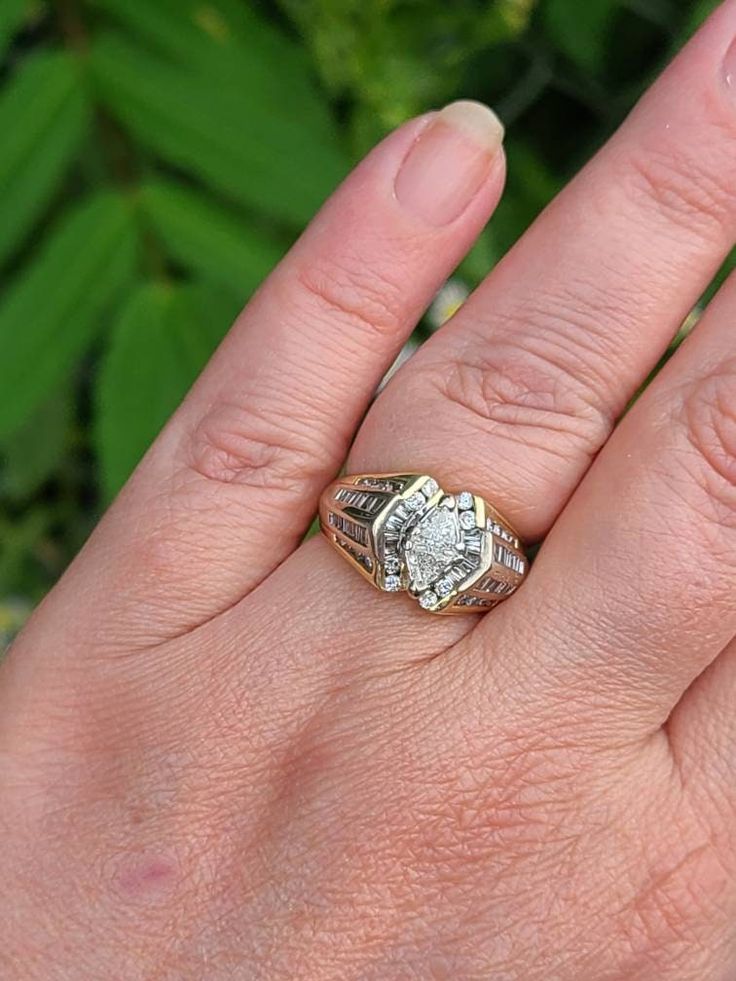 Vintage 14k Yellow Gold Trillion Cut Diamond Cluster Ring 1.67ct. T.w. Color H-J Clarity SI Size 7.25 with Appraisal Item w#2627 Professionally cleaned and polished to newer condition. .32 carat total weight Trillion Cut Diamonds (2) .60 carat total weight Round Cut Diamonds (24) .48 carat total weight Baguette Cut Diamonds. 1.67 carat total weight all diamonds Color H-J Clarity SI1 7.3 grams Marked 14k American Appraisal Association Estimated Retail Replacement Value $2395 USD We will provide 1 Diamond Jewelry With Marquise-cut Center Stone, Heirloom White Diamond Ring With Vs Clarity, Marquise Cut Diamond Jewelry With Center Stone, Heirloom White Diamond Ring Vs Clarity, Anniversary Ring With Prong Setting And Baguette Cut, Anniversary 14k White Gold Cluster Ring With Diamond Accents, Diamond Cluster Ring With Baguette Cut, Diamond Cluster Ring Baguette Cut For Promise, Dazzling Cluster Ring With Vvs Clarity For Anniversary