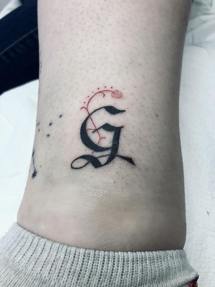 a woman's foot with a small tattoo on the lower part of her leg