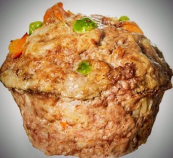 a close up of a muffin with meat and vegetables in it on a white background