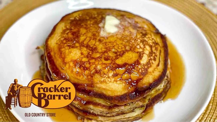 a stack of pancakes sitting on top of a white plate covered in syrup and butter