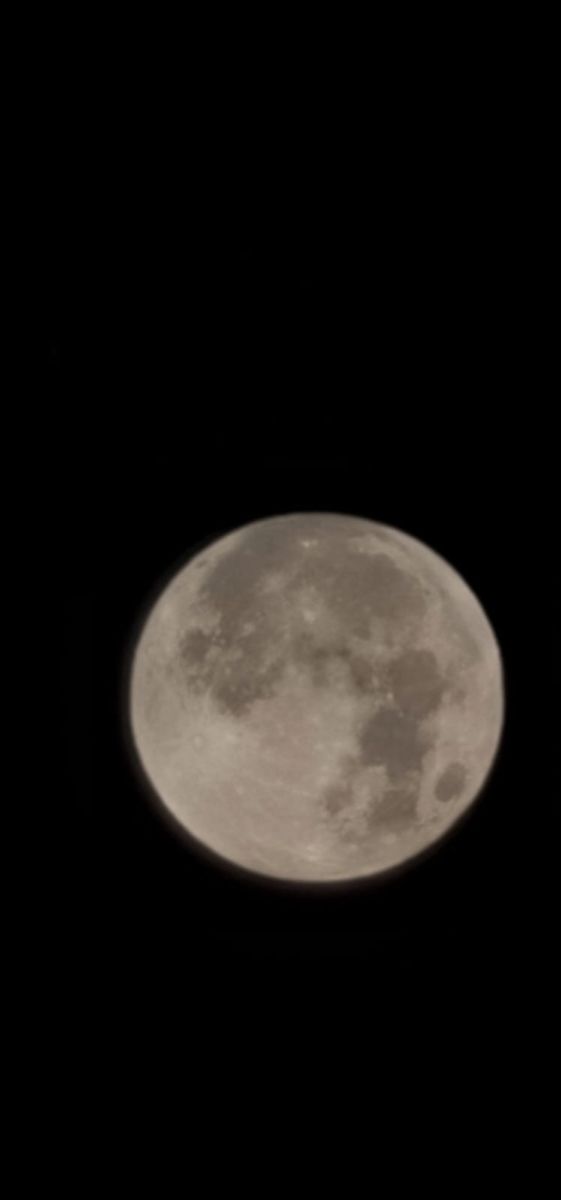 an airplane flying in the sky at night with a full moon behind it's back