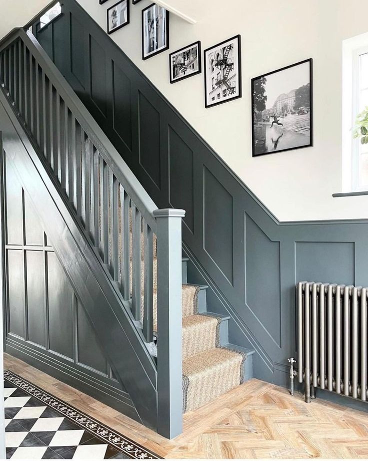 a staircase with pictures on the wall next to it and a radiator below