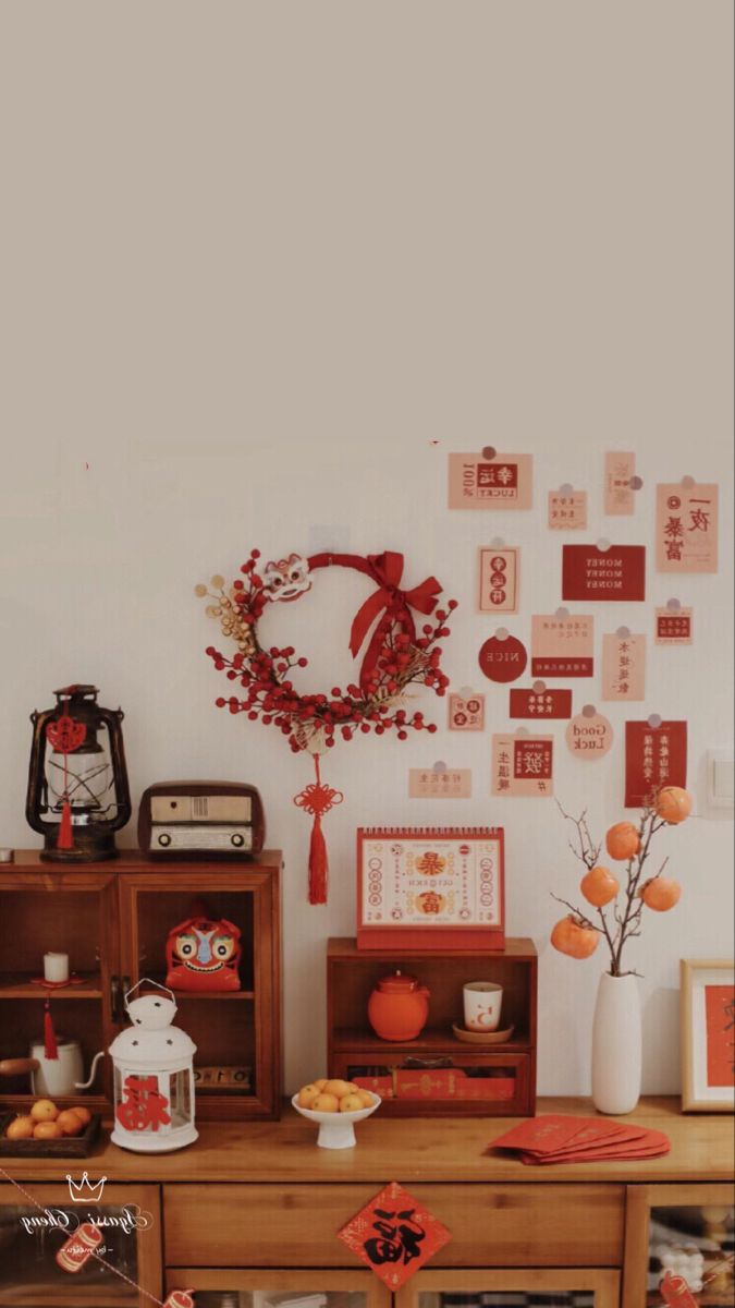 a wooden table topped with vases filled with flowers next to a wall covered in pictures