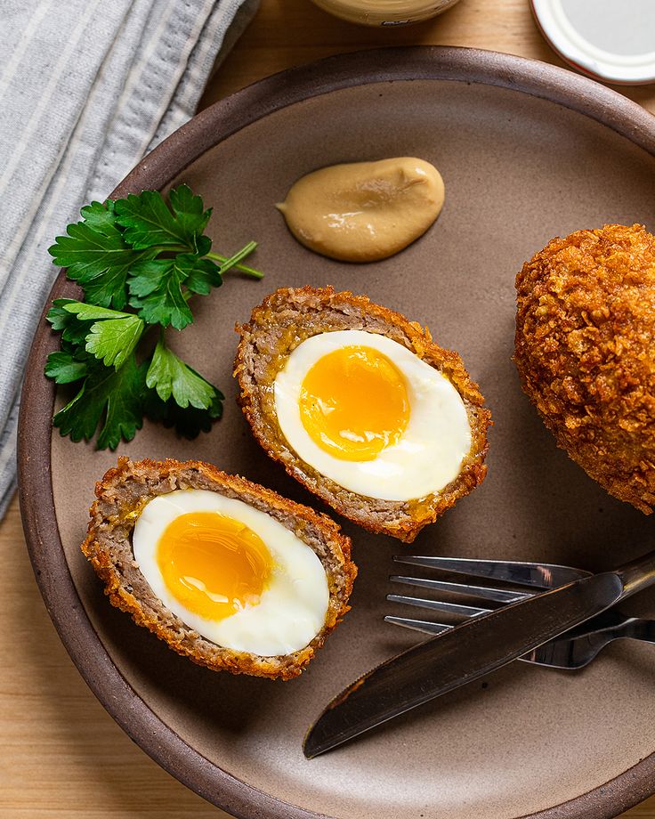 an egg is in the middle of two muffins on a plate with a fork