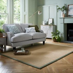 a living room scene with focus on the couch and chair, coffee table and fireplace