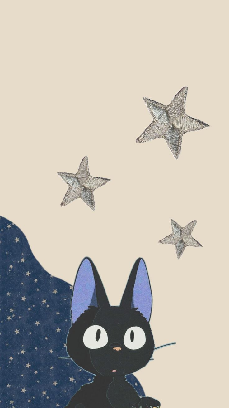 a black cat sitting on top of a table next to stars