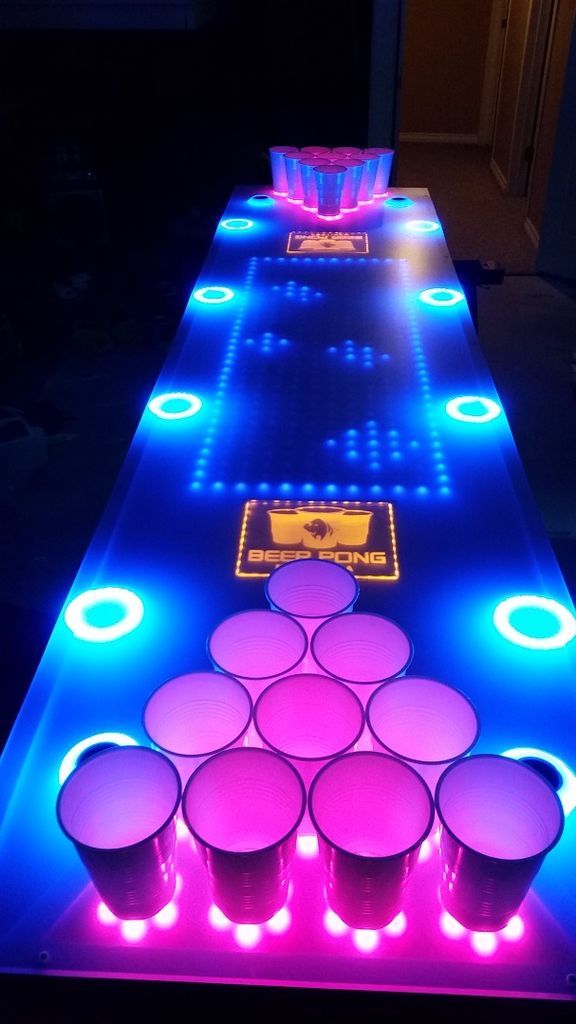 an illuminated table with cups and neon lights