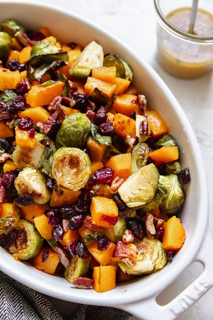 brussel sprouts, brussels sprouts and cranberries in a white casserole dish