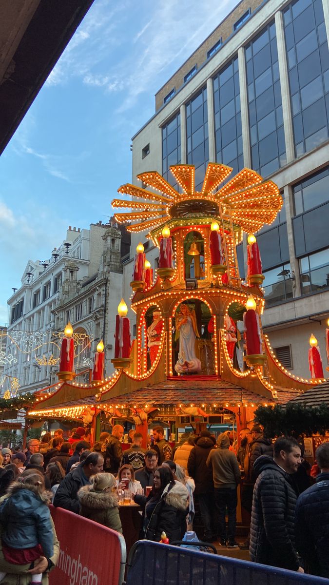 people are standing in front of an elaborately decorated building with lights on it's sides