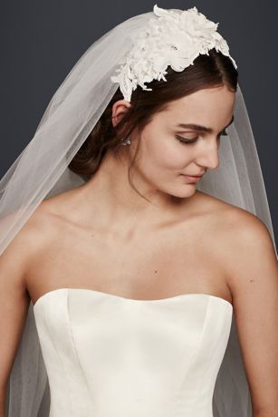 a woman wearing a wedding veil with flowers in her hair