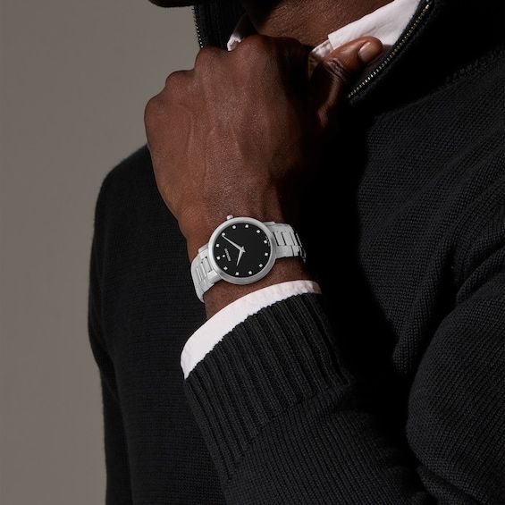 The height of modern luxury, this Movado Faceto men's watch is an elegant choice. 39mm stainless steel case with polished bezel Black enamel dial with diamond markers, steel dauphine hands and sapphire crystal Bevel-edged stainless steel bracelet with push-button deployment clasp Water-resistant to 30 meters Designer Watch With Date Indicator And Round Dial, Luxury Stainless Steel Business Watch, Business White Gold Diamond Watch With Metal Dial, White Gold Diamond Watch With Metal Dial For Business, Modern Business Watches With Diamond Hour Markers, White Gold Diamond Watch For Business, Designer Silver Watch With Date Indicator, Silver Business Watches With Diamond Hour Markers, Designer Silver Watches With Date Indicator