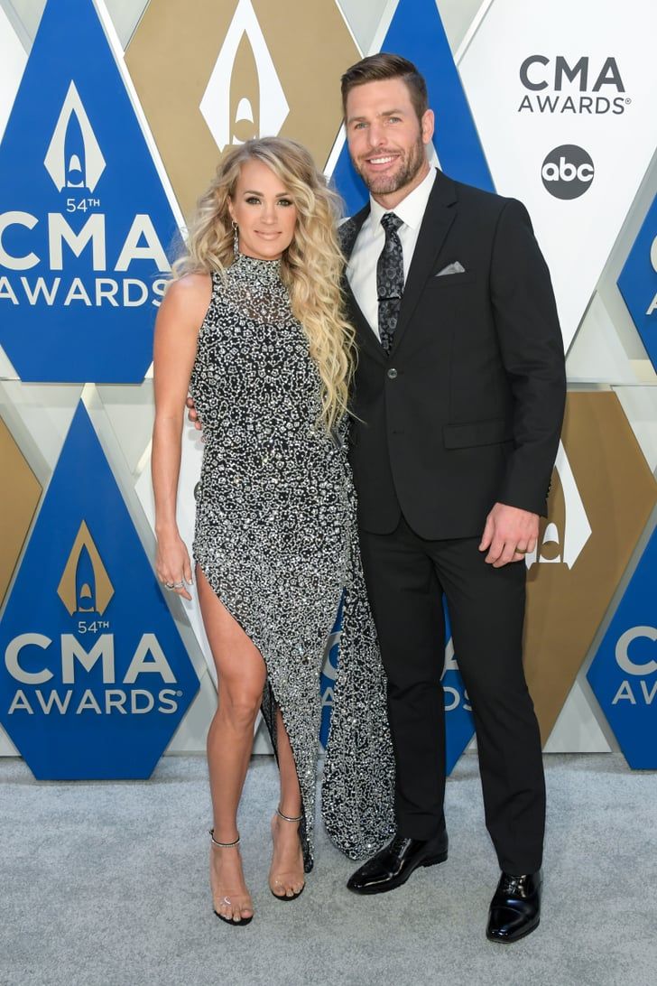 a man and woman standing next to each other on a red carpet