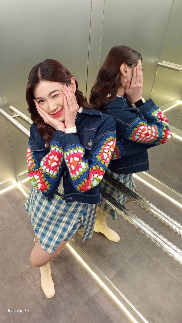 a woman standing in front of a mirror with her hands on her face