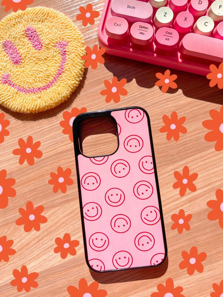 a pink phone case sitting on top of a wooden table next to a keyboard and mouse