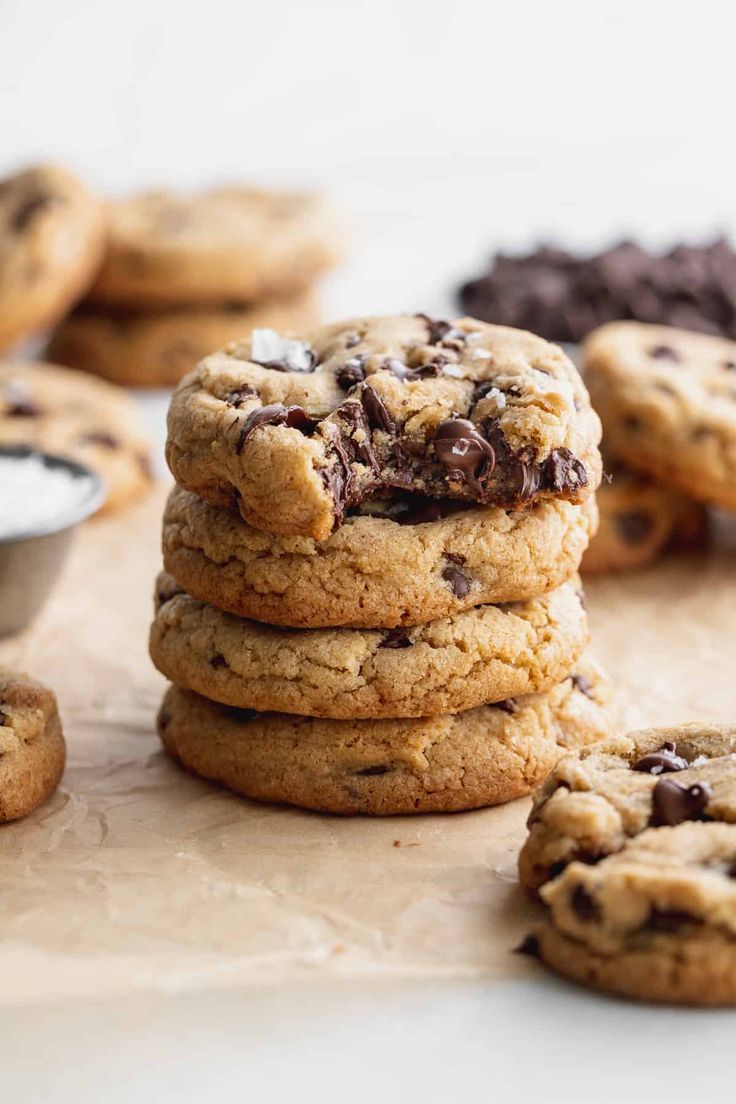 chocolate chip cookies stacked on top of each other with one cookie in the middle next to it