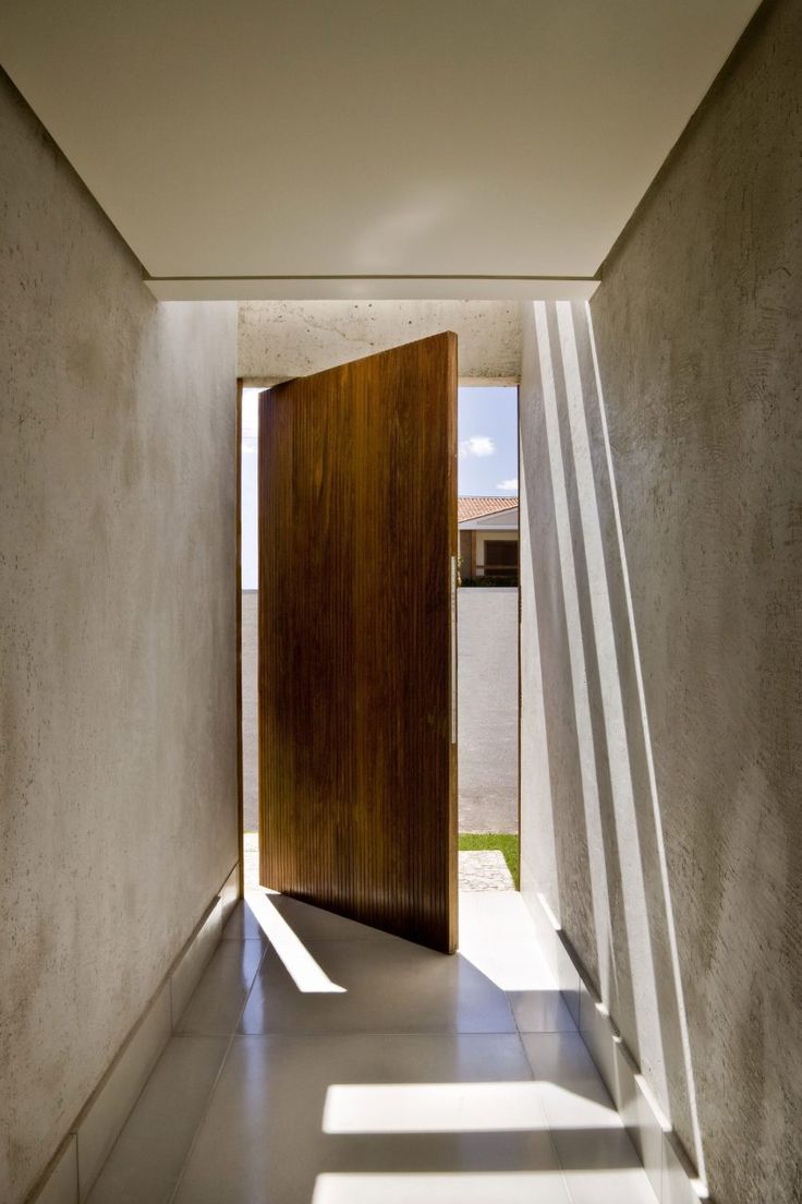 an open door in the middle of a hallway with light coming through it and casting shadows on the floor