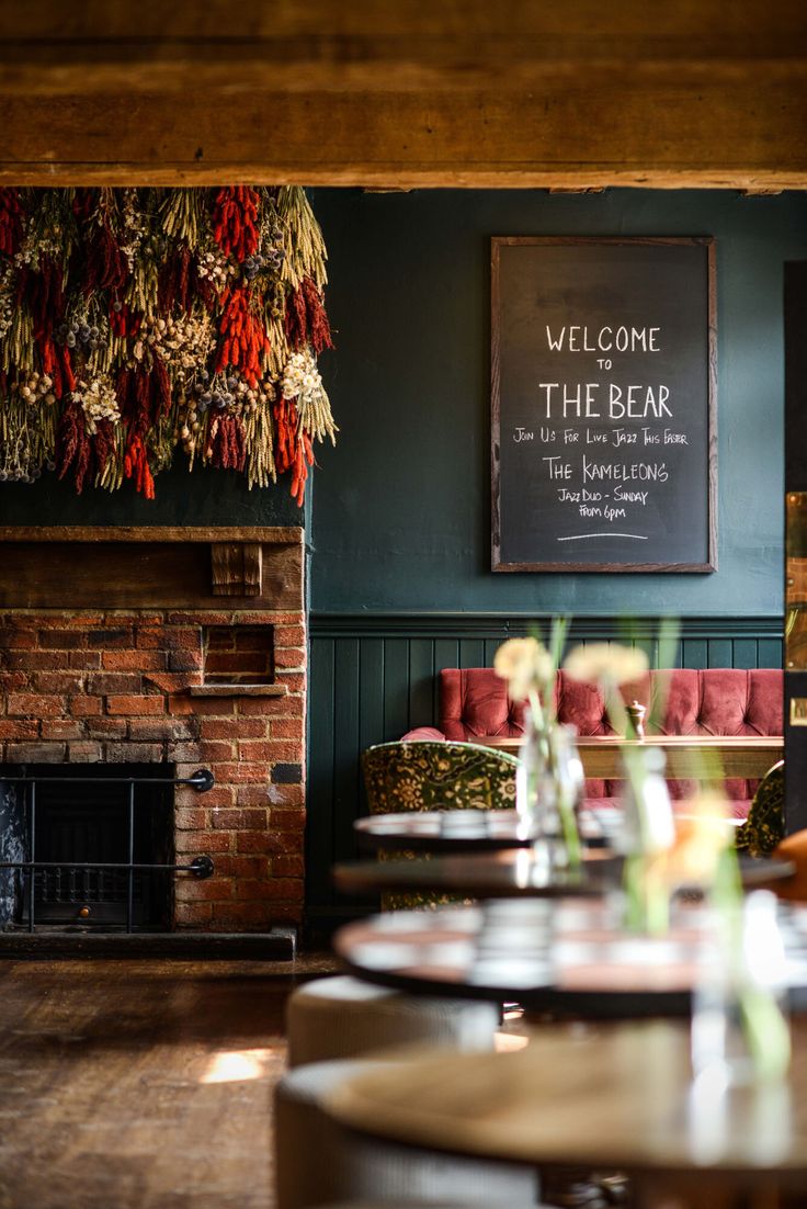 a restaurant with tables, chairs and a fireplace