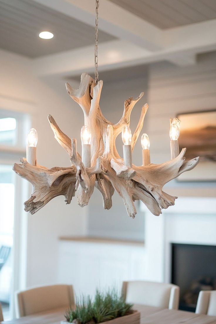 a chandelier made out of driftwood is hanging in the middle of a dining room