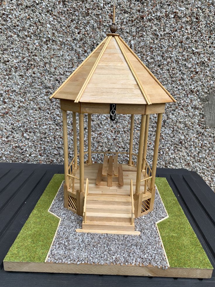 a small wooden gazebo with steps leading up to it