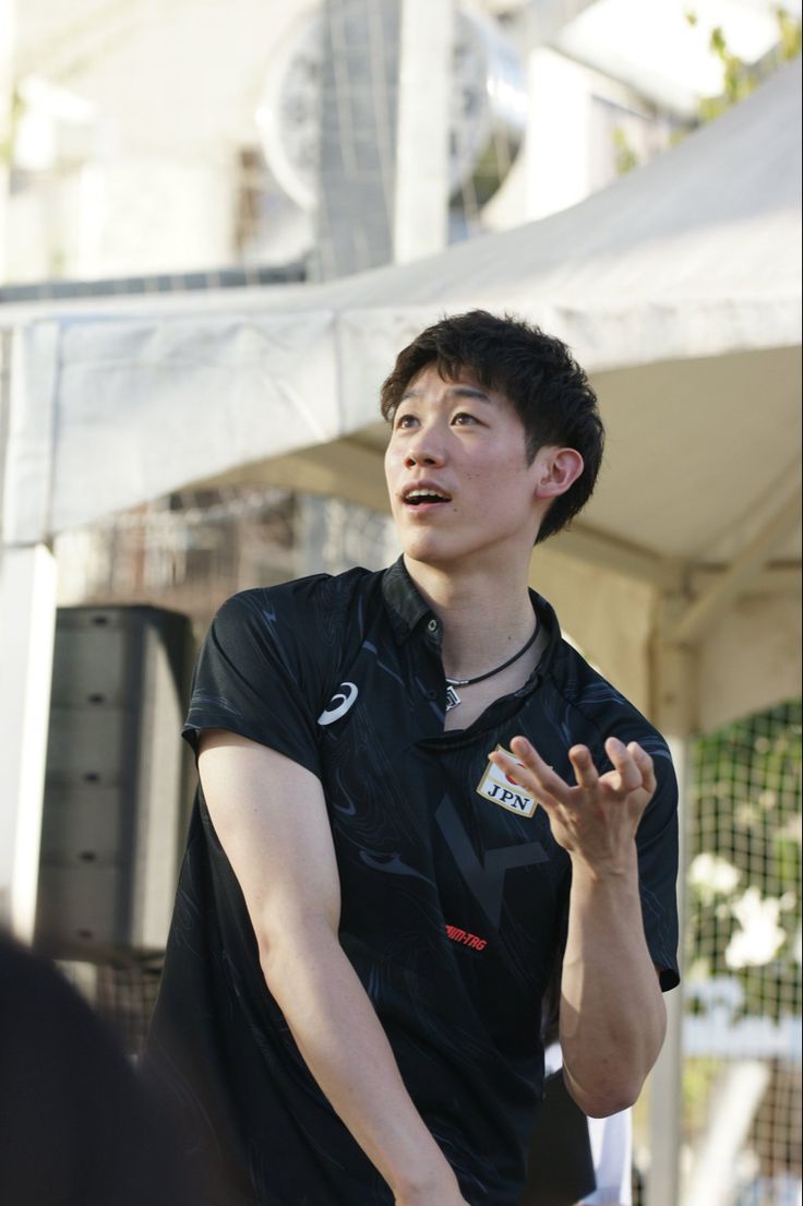 a young man holding a tennis racquet on top of a tennis ball court