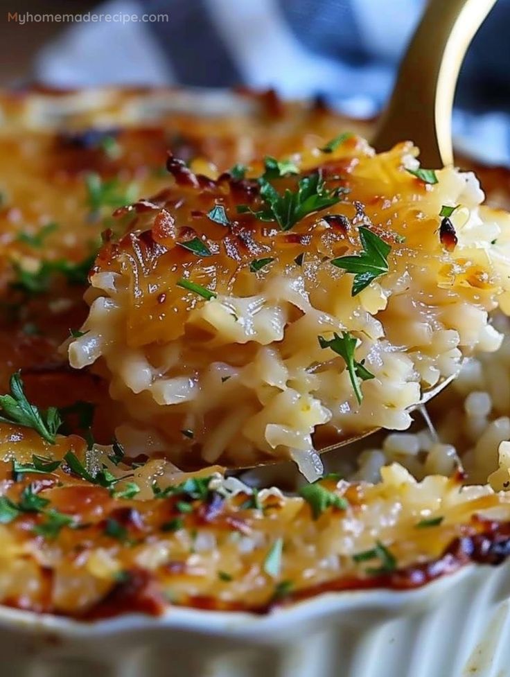 a spoon full of macaroni and cheese being lifted from a dish with parsley