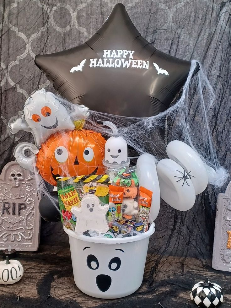 a bucket filled with halloween decorations and balloons