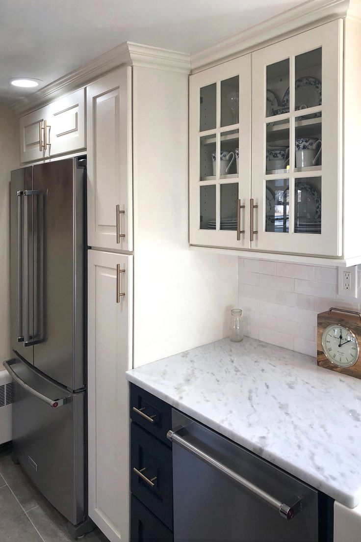 a kitchen with marble counter tops and white cabinets