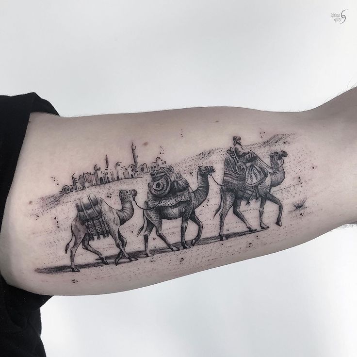 a man's arm with three camels on it