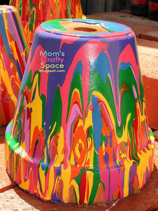 two brightly colored vases sitting on the ground