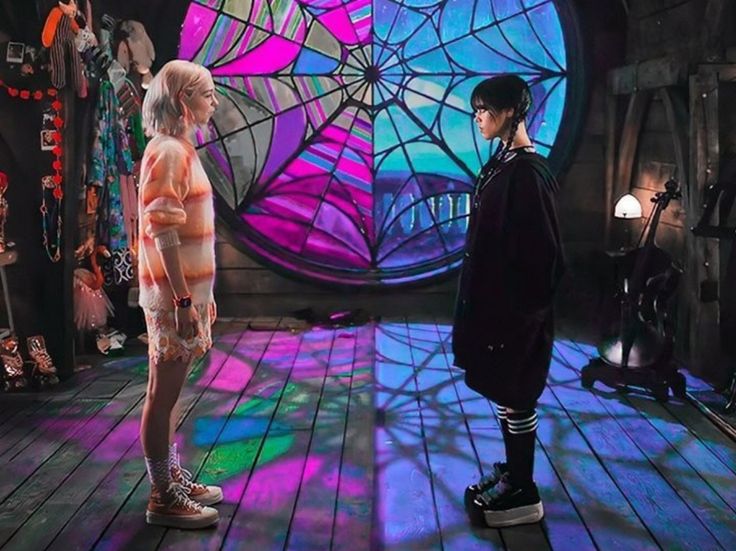 two people standing on a wooden floor in front of a stained glass window with colorful lights