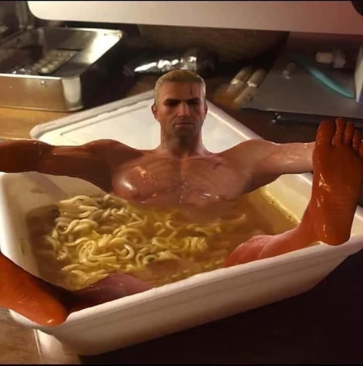 a man with no shirt in a bowl of noodles