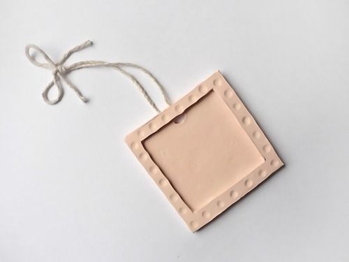 an empty tag hanging from a string on a white surface