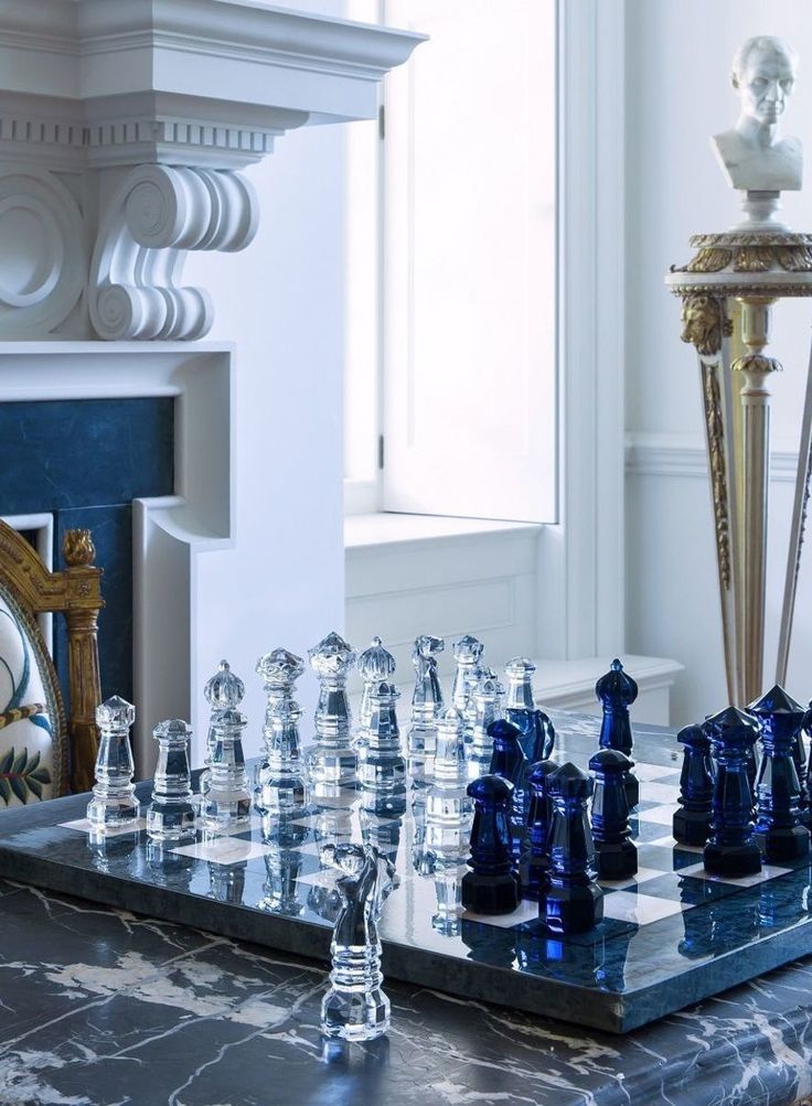 a glass chess set sitting on top of a marble table