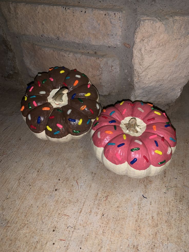 two donuts with sprinkles are sitting on the floor next to each other