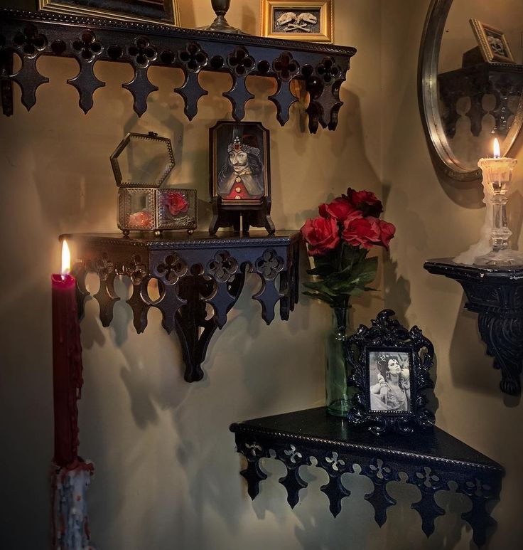 a shelf with candles and flowers on it next to a mirror, clock and other items