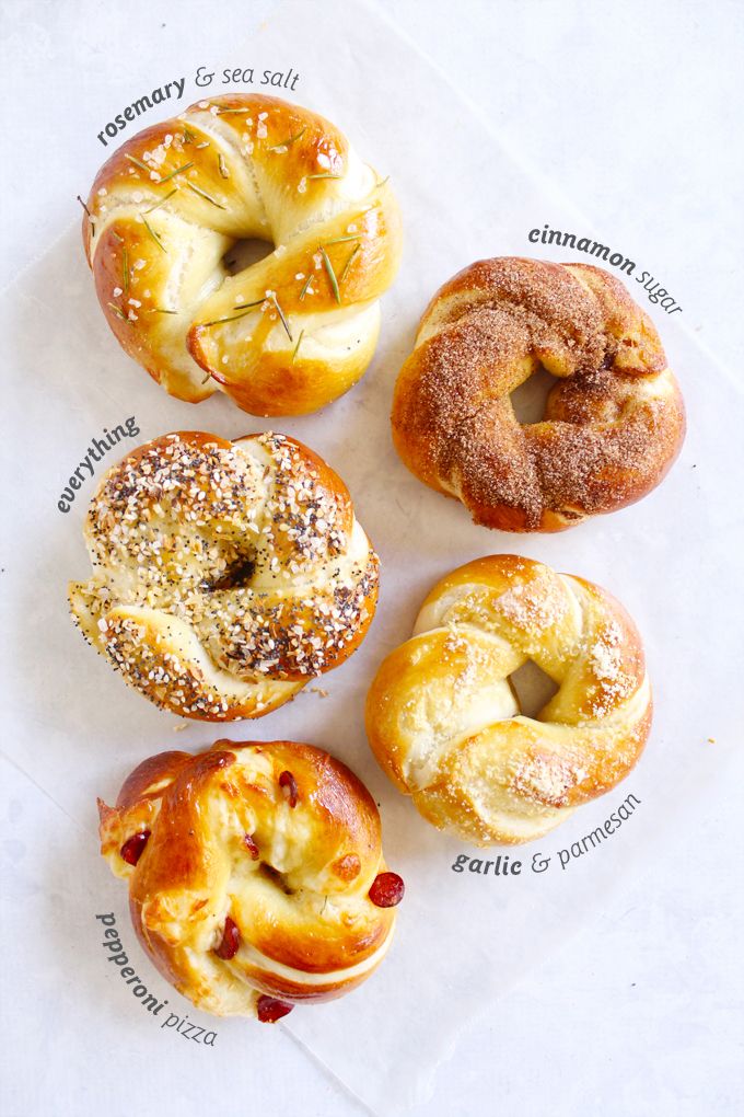 four different types of doughnuts with sprinkled toppings on white paper