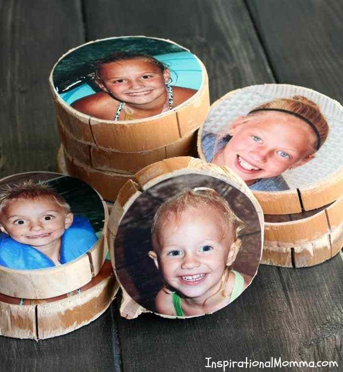 four small wooden boxes with pictures of children in them on top of a wood table