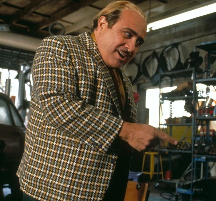 a man in a suit and tie standing next to a car