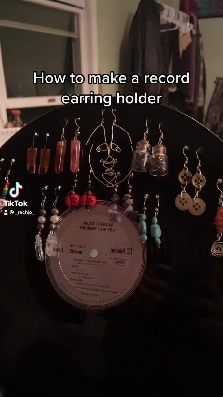 a record with earrings hanging from it and the words how to make a record earring holder