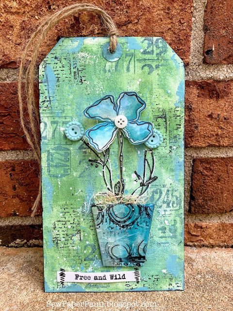 a blue flower pot hanging on a brick wall with the words free and wild written below it