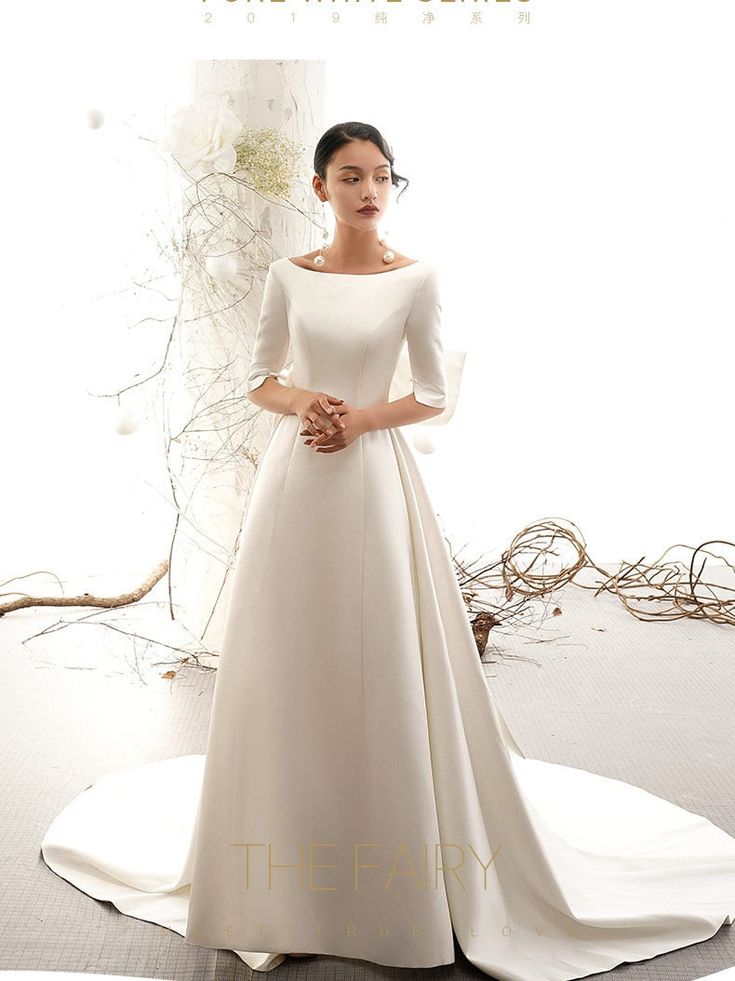 a woman in a white wedding dress standing on the floor