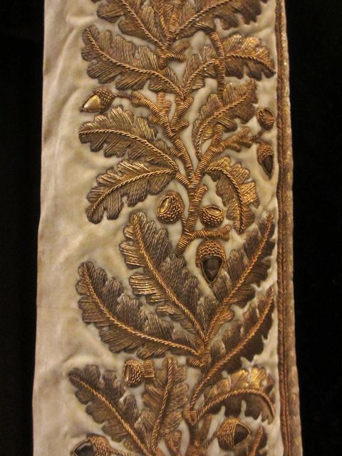 an embroidered piece with gold leaves on it