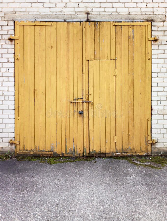 an old yellow wooden door in front of a white brick wall royalty images and stock photos