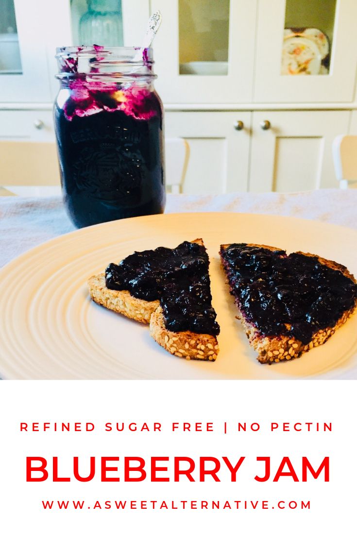 two pieces of toast on a plate with blueberry jam in a jar next to it